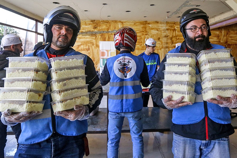 Members of motorcycle club Hope Bikers Syria help prepare distribute 