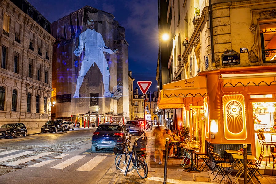 A photograph of Bronze medalist Bolade Apithy of Team France reacting during the Men's Sabre Team Bronze Medal Match on day five of the Olympic Games Paris 2024 at Grand Palais is projected as part of Parisienne Projection on July 31, 2024 in Paris, France. 
Image: Hector Vivas/Getty Images 