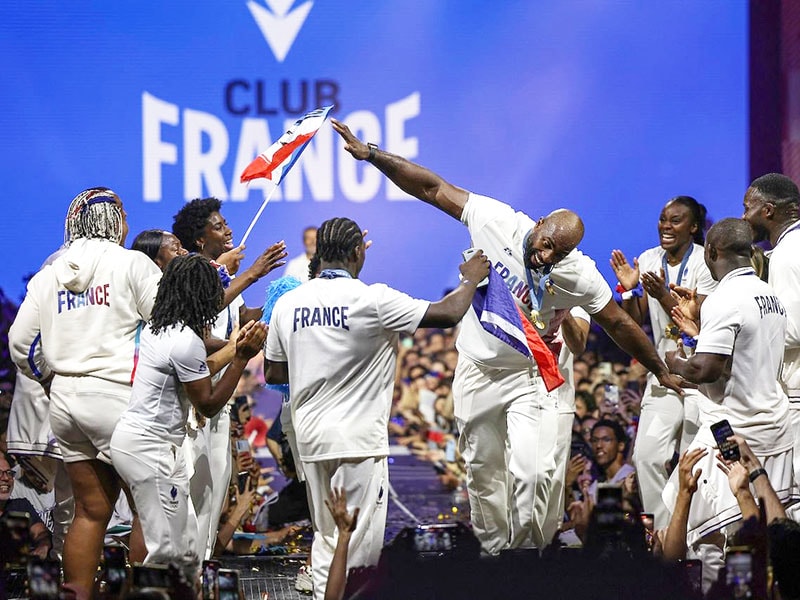 
France's Teddy Riner (CR) and French judo team celebrate with supporters at the 