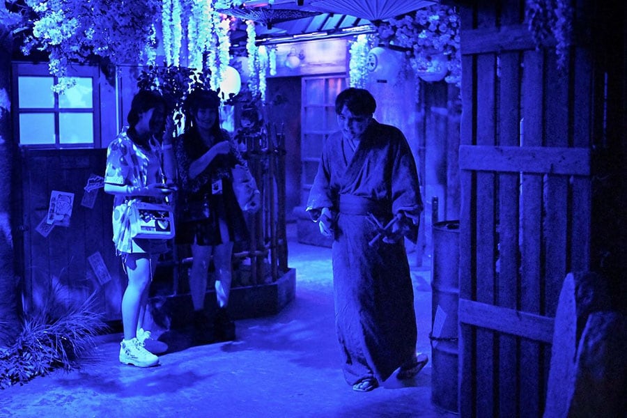 Visitors watching a kimono-clad performer roaming around while groaning like a zombie at a haunted house of the Namjatown indoor theme park in Tokyo Image: Kazuhiro Nogi / AFP©