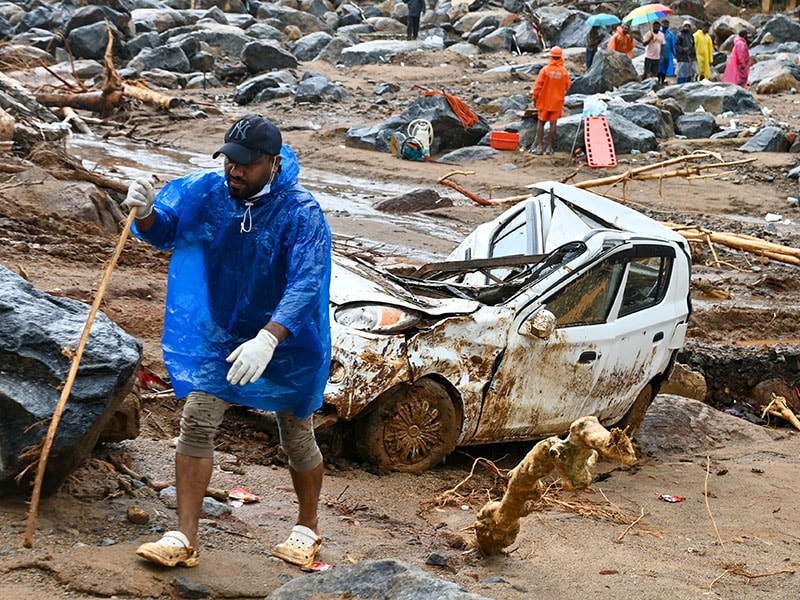 A man walks past a damaged vehicle after the landslides in Wayanad on August 1, 2024. - Indian rescue crews scoured mud-caked tea plantations and villages on August 1 with little hope of finding more survivors from landslides that killed around 200 people. <br> Image: Idrees Mohammed / AFP