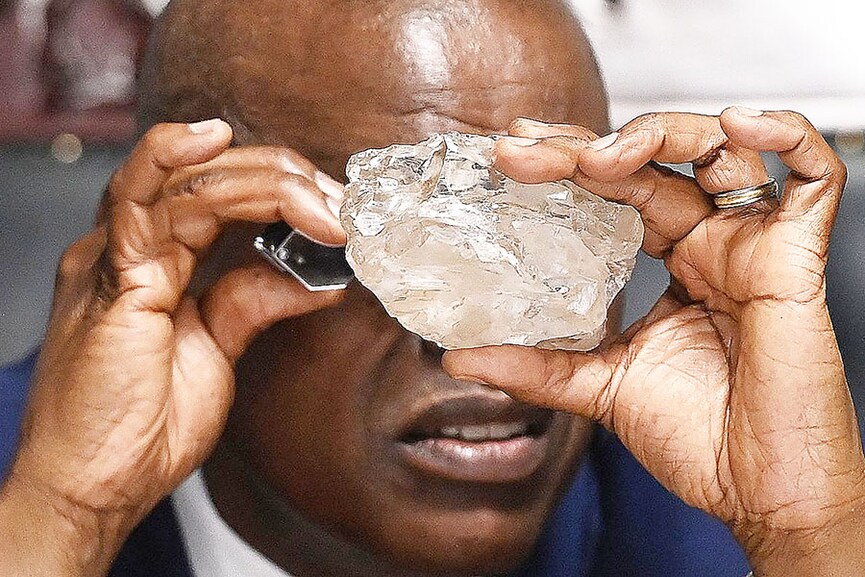 
Botswana's President Mokgweetsi Masisi looks at a large diamond discovered in Botswana at his office in Gaborone on August 22, 2024.
Image: Monirul Bhuiyan / AFP©