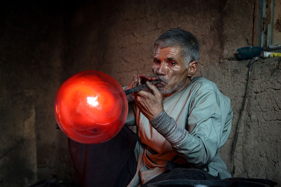  Ghulam Sakhi Saifi, an Afghan glassblower, crafts a glassware at his traditional workshop in Afghanistan's western city of Herat. 
Image: Mohsen Karimi / AFP©