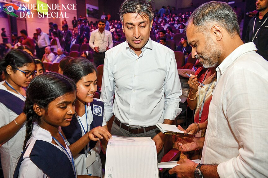 Rishad Premji (centre), Wipro’s executive chairman and the eldest son of founder Azim Premji, and chief sustainability officer Anurag Behar meet schoolchildren at an event Image: Manjunath Kiran/ AFP