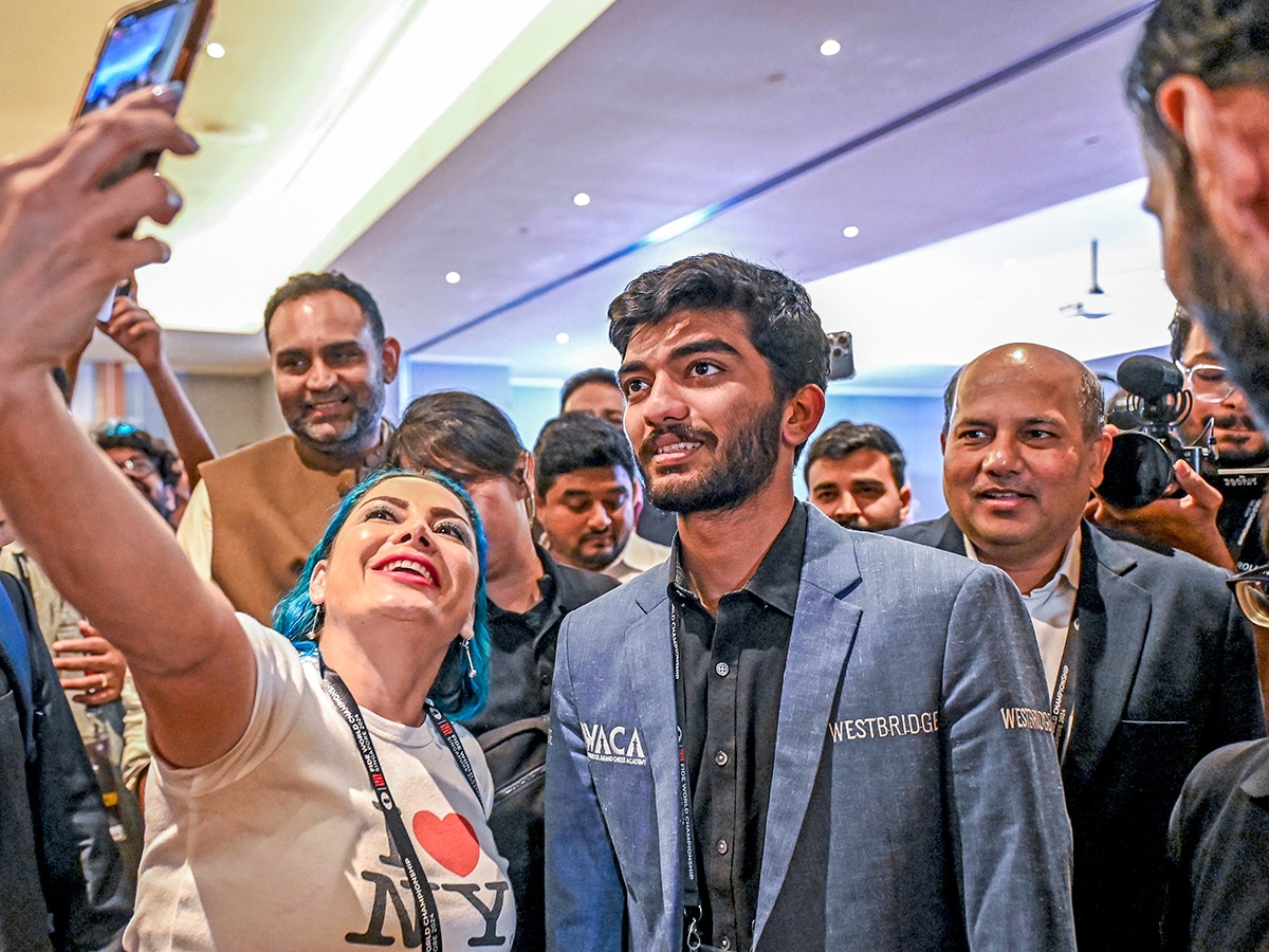 A fan takes a selfie with India's grandmaster Gukesh Dommaraju (C) after his win against China's chess grandmaster Ding Liren in game 14 of the 2024 FIDE World Championship in Singapore on December 12, 2024. Image: Simon Lim / AFP