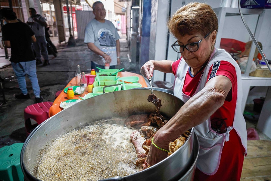 Maria del Pilar Cortes (R) works in her taqueria named 