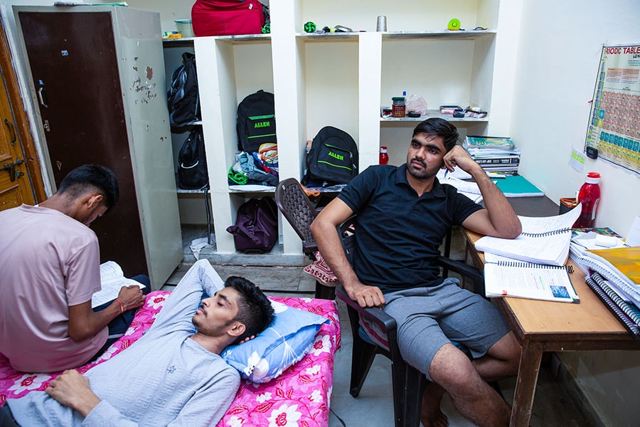 The results we see are a product of what goes on inside a tiny room in Kota. Students study day and night, with no time to get adequate sleep, pursue hobbies, sports or indulge in any form of entertainment. And it'll all be back to this, should there be no ReNEET, says Dilip Beniwal (sitting, in black tshirt). Image: Madhu Kapparath