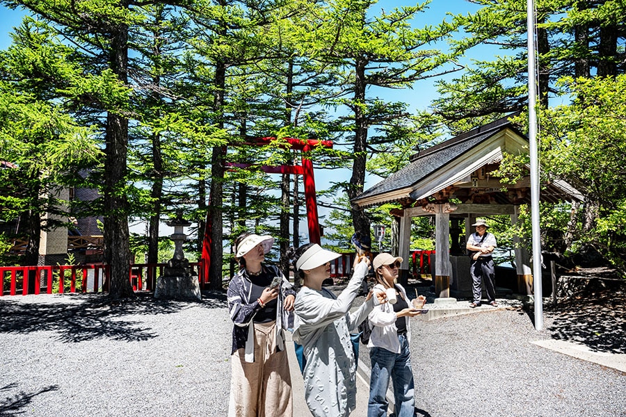 People visit the Komitake shrine near the Fuji Subaru Line 5th station, which leads to the popular Yoshida trail for hikers climbing Mount Fuji at Narusawa, Yamanashi Prefecture, on June 19, 2024. AFP_JapanTourismFuji. Image: PHILIP FONGAFP