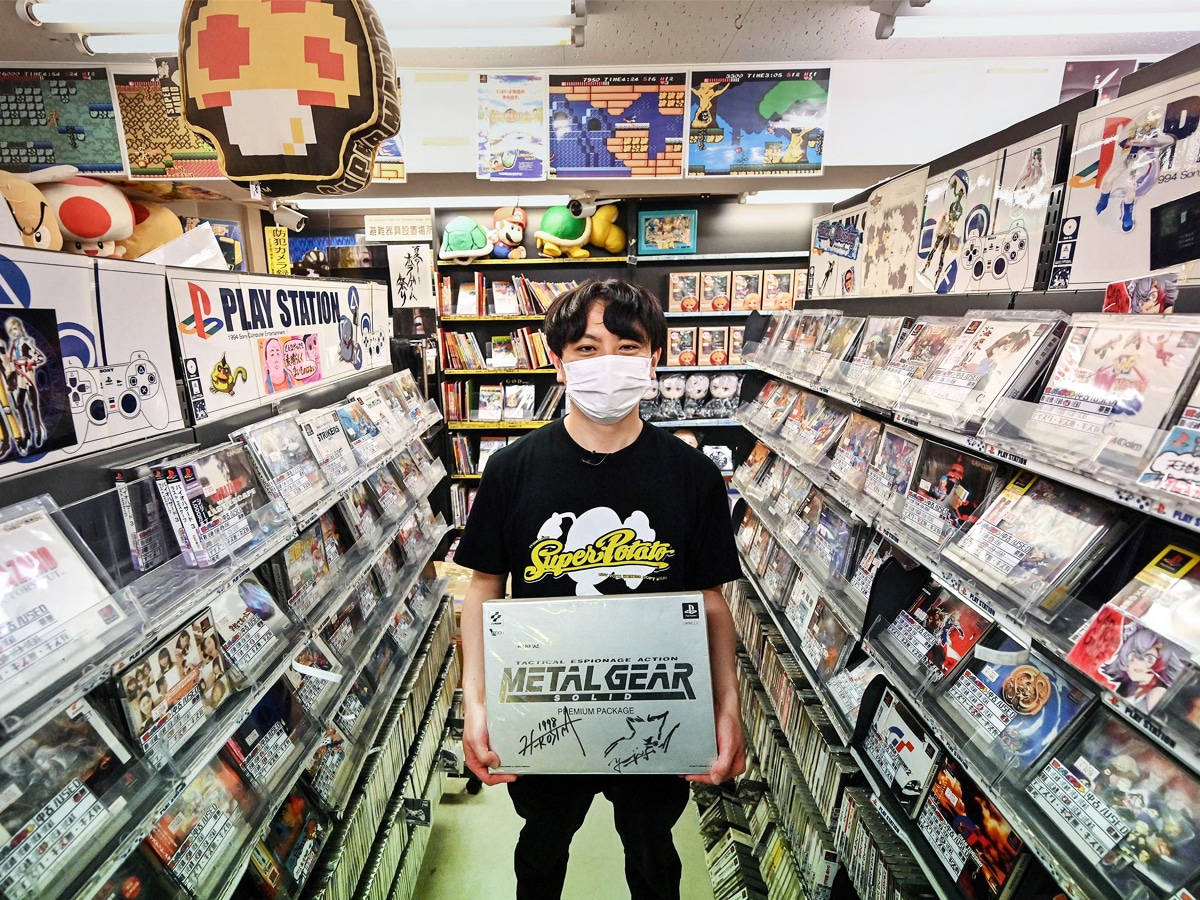 Shop manager Komura-san posing with a signed Metal Gear box, at “Super Potato”, a shop selling vintage video games and memorabilia in the popular electronics shopping area of Akihabara. Image credit: Photography Richard A. Brooks / AFP