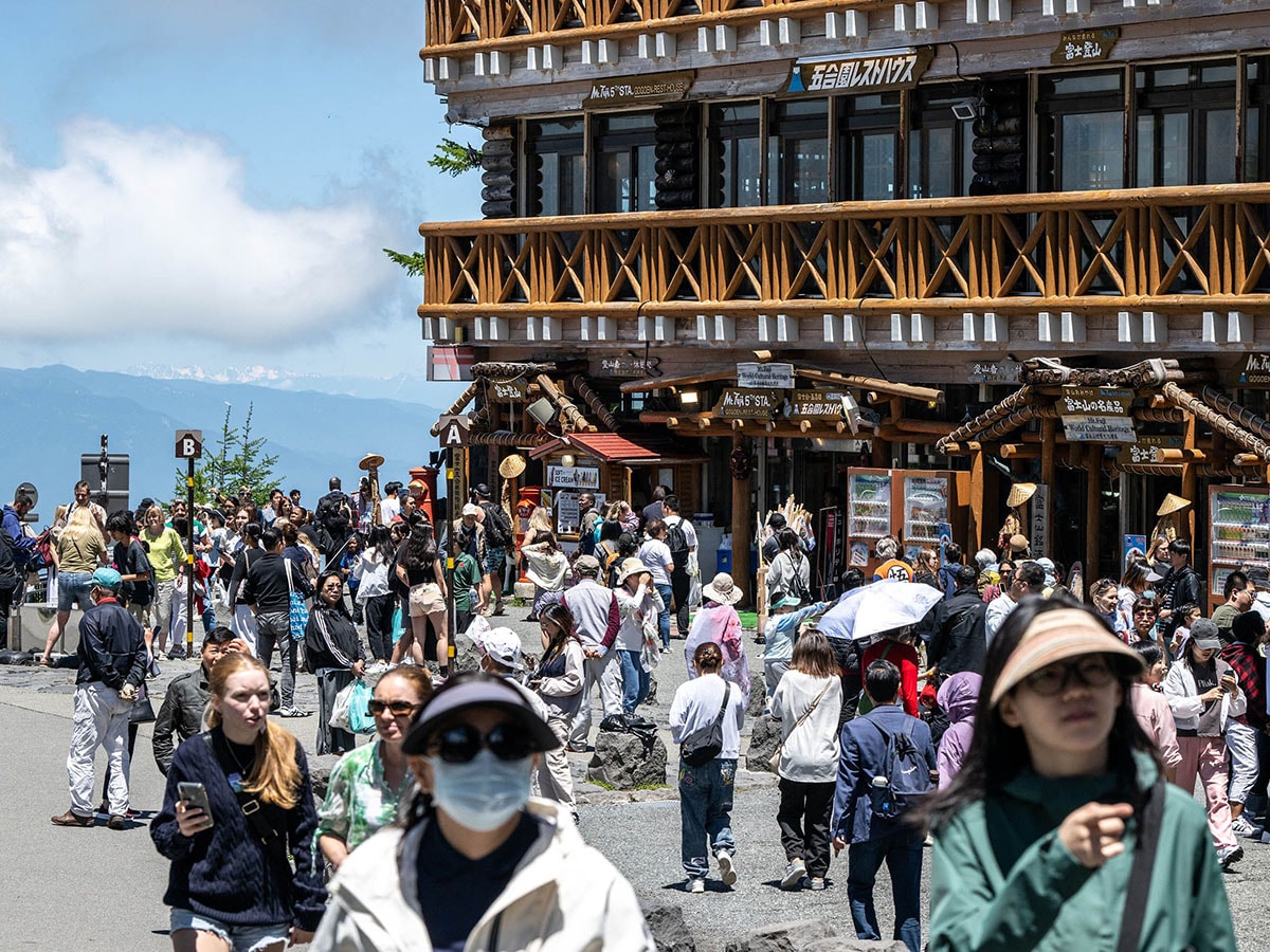 Tourists are seen in front of the restaurant and shopping area of the Fuji Subaru Line 5th station, which leads to the popular Yoshida trail for hikers climbing Mount Fuji. Image: Photography Philip FONG / AFP