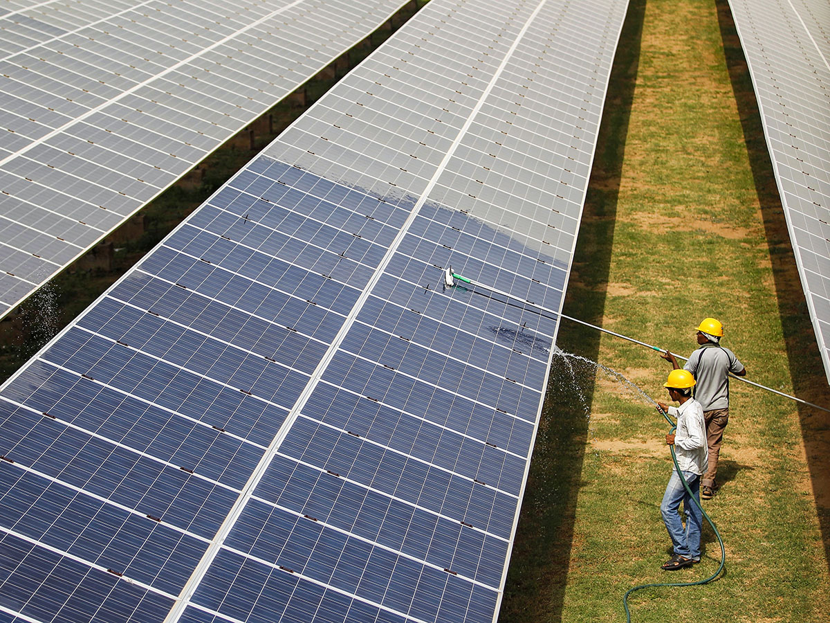 Workers clean photovoltaic panels inside a solar power plant in Gujarat, India.
Image: Reuters/Amit Dave