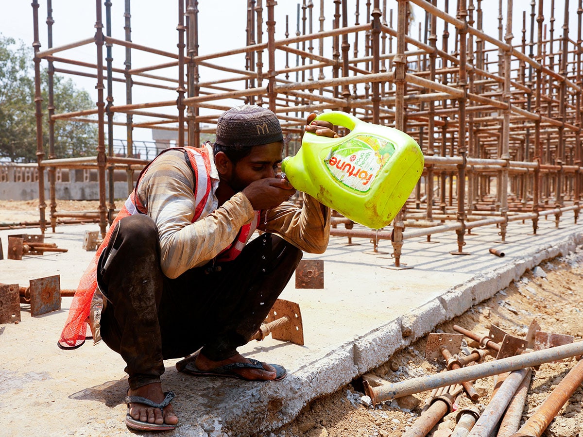 This file photo shows a construction worker drinking water from a container as he takes a break at a construction site during a hot summer day in New Delhi, India Image: Priyanshu Singh / Reuters