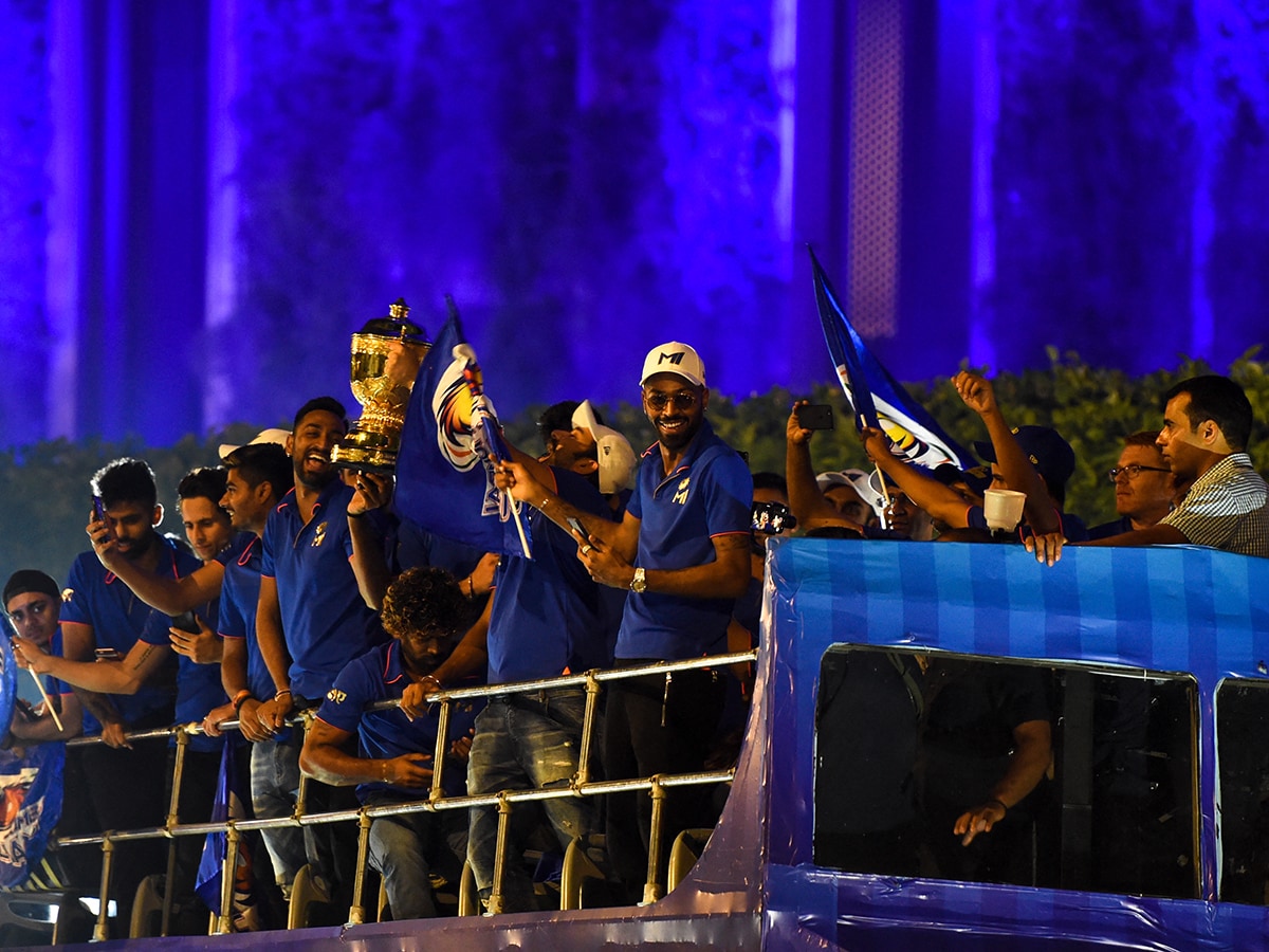 Mumbai Indians cricket team members gesture and celebrate as they travel in a open bus during a celebration procession after arriving in Mumbai on May 13, 2019. Mumbai Indians team won the 2019 Indian Premier League (IPL) Twenty20 cricket tournament title. Photo by PUNIT PARANJPE/AFP via Getty Images