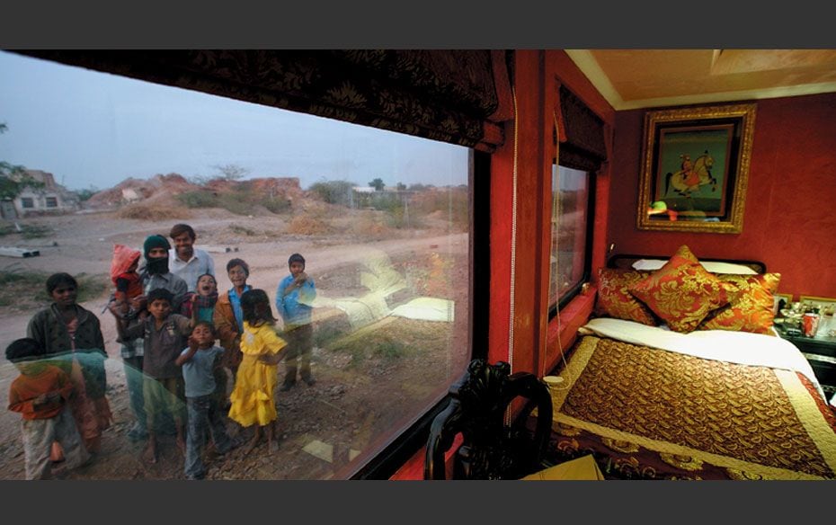 Villagers react to the camera from outside the luxury train, Royal Rajasthan on Wheels, where suites