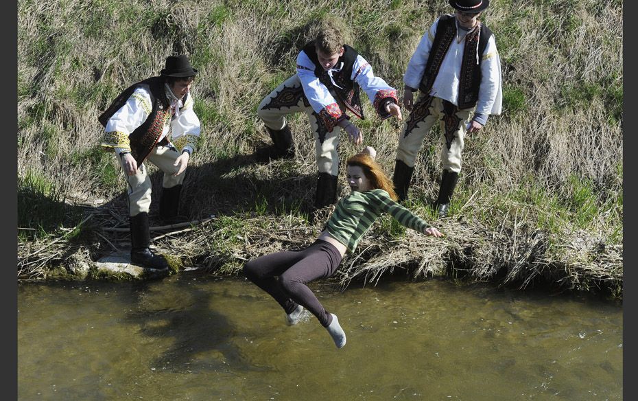 That Chilly Feeling Slovak youths dressed in traditional costumes throw a girl into a creek as part 