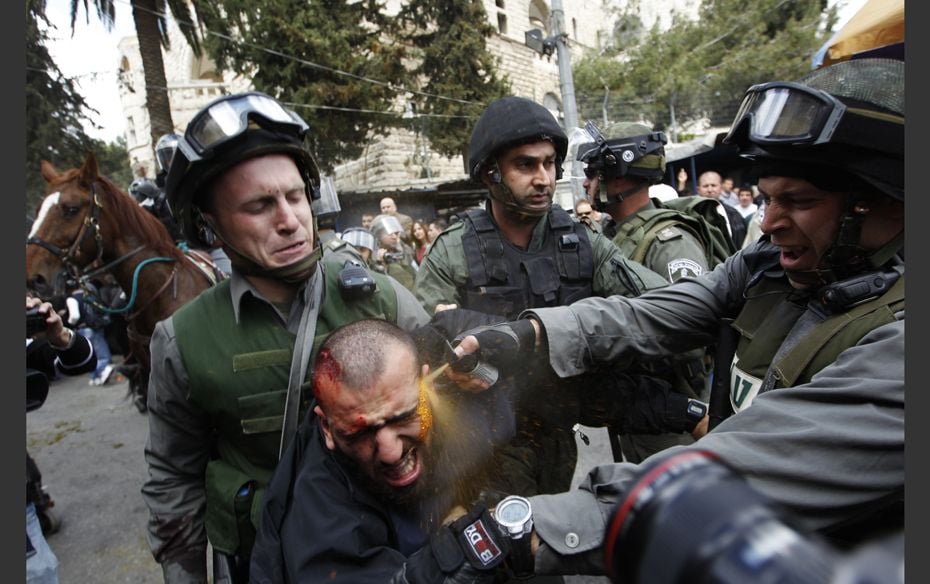 Old Battles Israeli border police officers use pepper spray as they detain an injured Palestinian pr