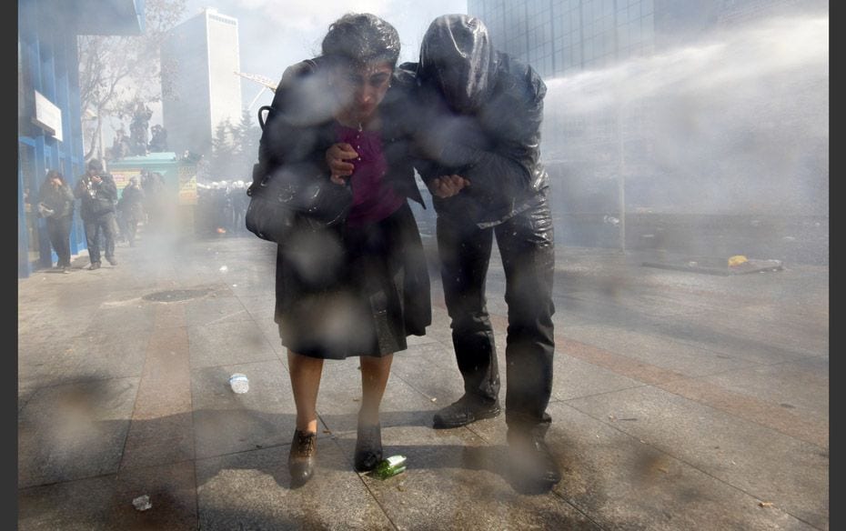 Changing School Rules Sebahat Tuncel (L), a Kurdish member of parliament, runs for cover as riot pol