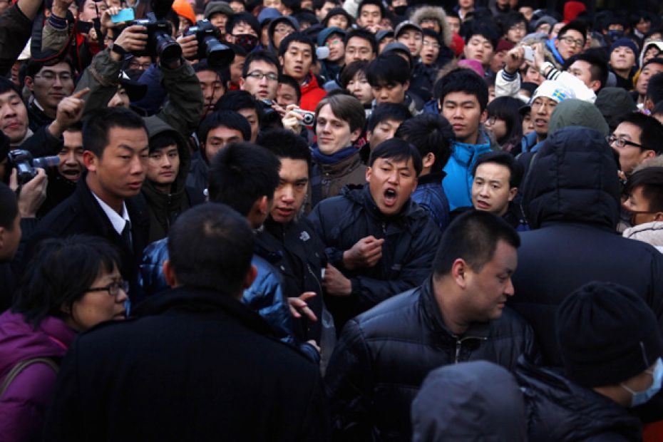 A man yells at a security guard after the guard tried to remove a member of the crowd at the Apple s