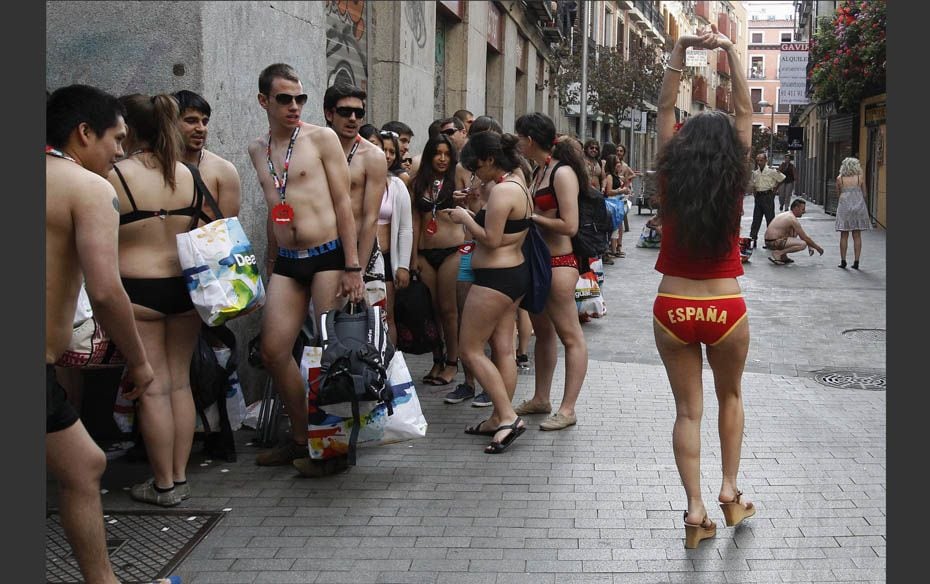 People in their underwear queue up as they wait to get clothes for free, outside a clothing store in