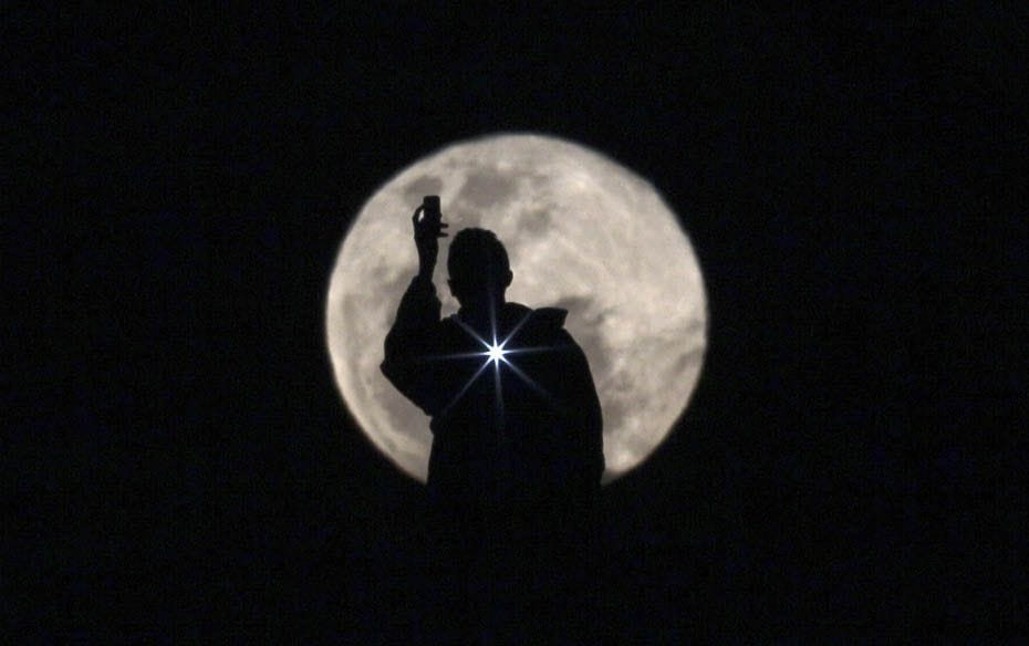 A man is seen photographing the full moon in Brasilia, Brazil                        