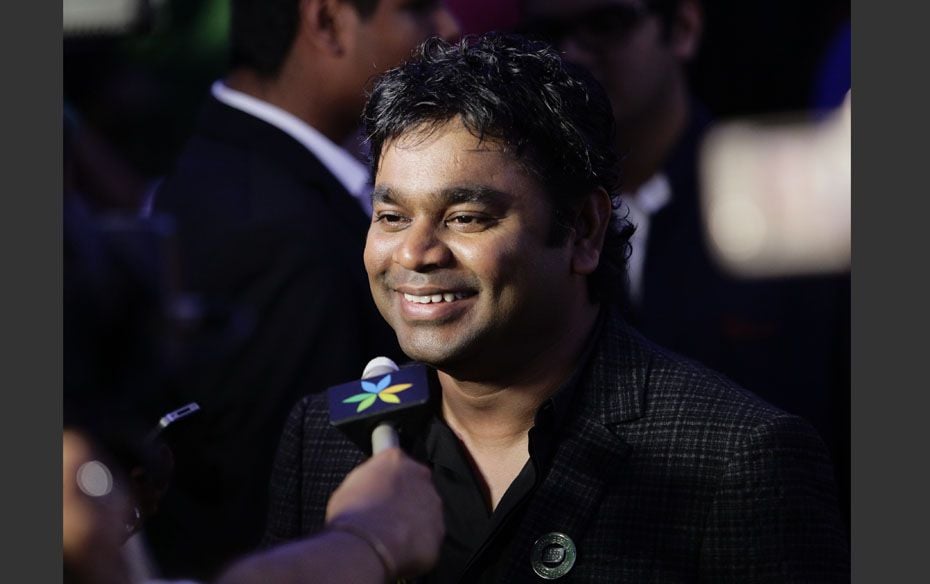 Music director A. R. Rahman smiles while speaking to a reporter upon his arrival on the green carpet