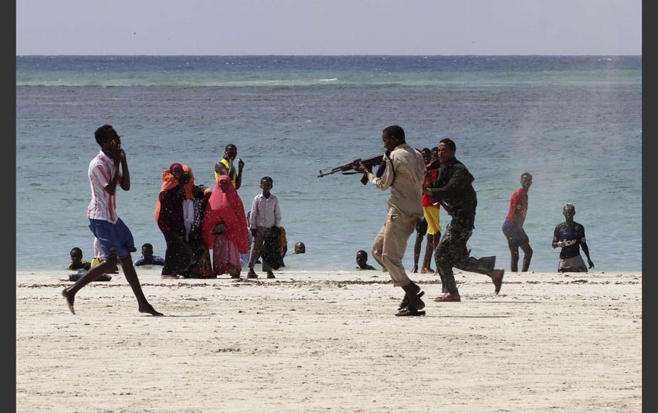 A Somali police officer (R) arrests a suspected rebel member (L) of the Al Qaeda-affiliated al Shaba
