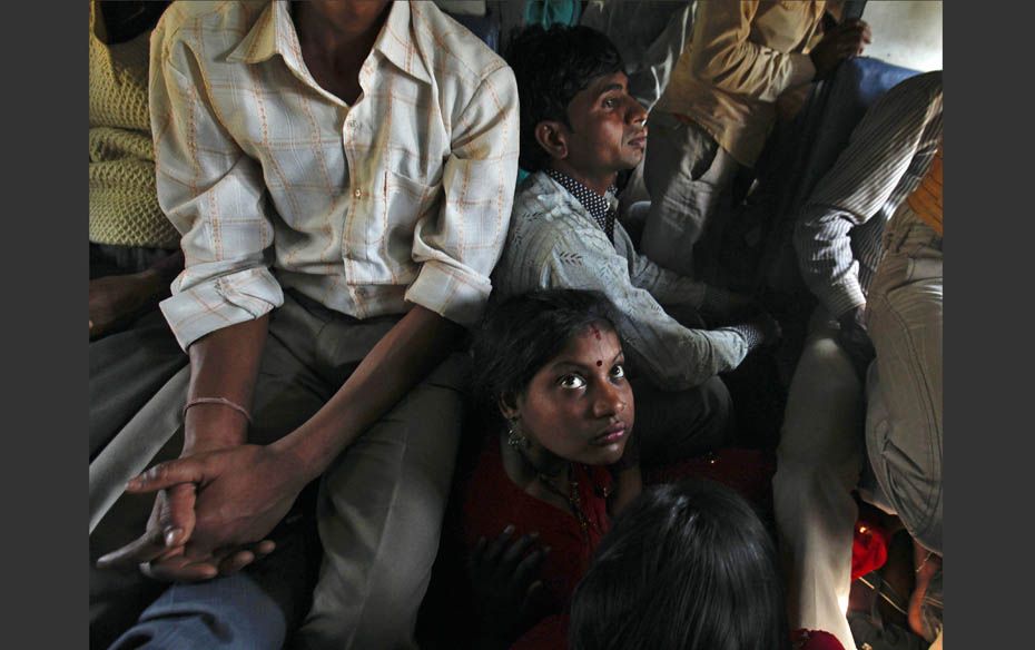 Passengers sit on the floor while travelling inside an overcrowded general class compartment of the 