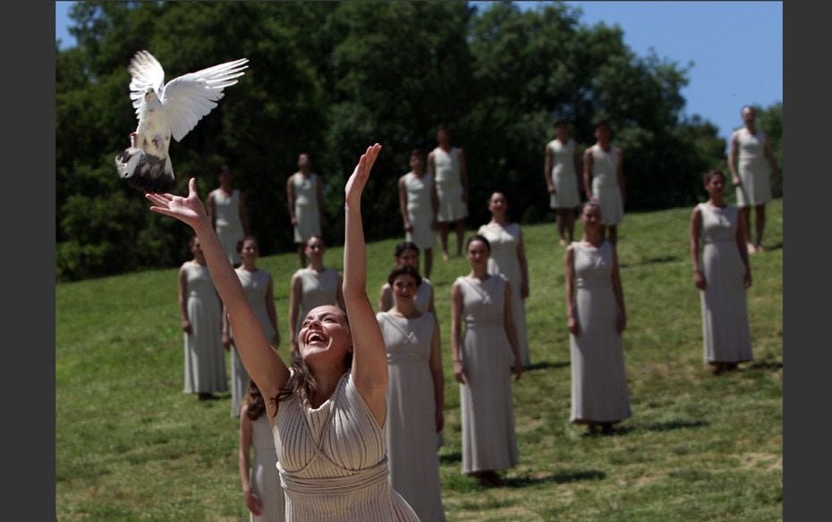 An actress, playing the role of a priestess, releases a dove during the dress rehearsal for the torc