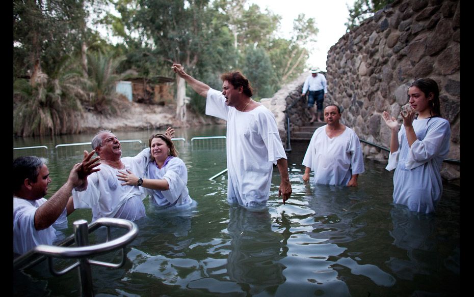 Christian pilgrims take part in a group baptism exercise in the waters of the Jordan River on Octobe