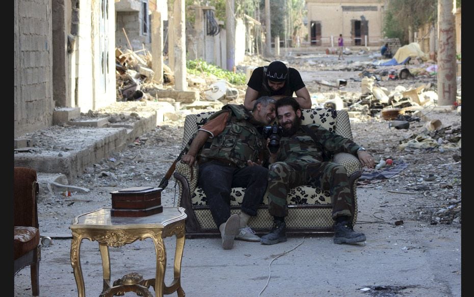 Free Syrian Army fighters look at photos on a camera in Mouazafeen neighbourhood in Deir al-Zor     