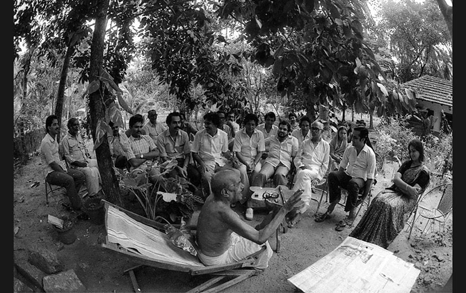 The image is a portrait of the writer under a mangosteen tree in his compound at Kozhikode, Kerala. 