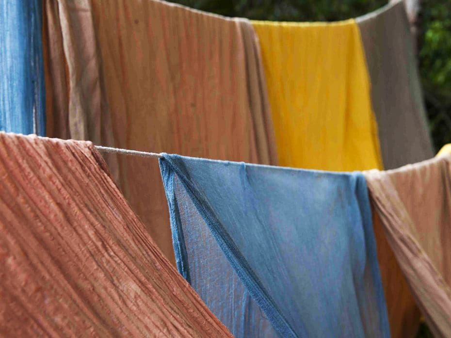 Ayurvastra fabrics, dyed in various colours and dried, hang on a clothes line at the society. Common