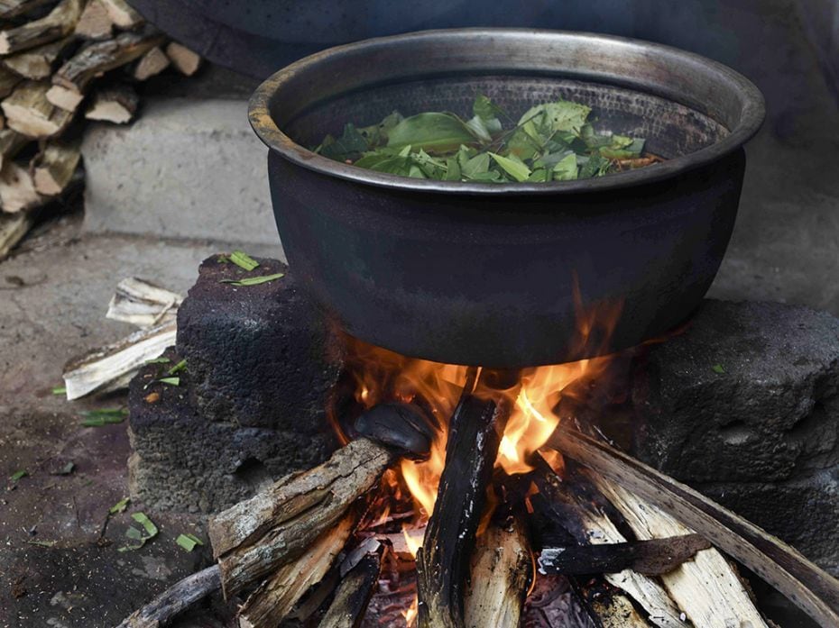 The mixture simmers over firewood                        