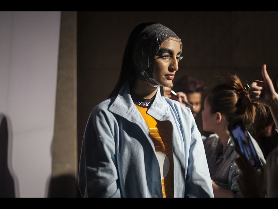 A model sports an interesting headpiece, waiting for her turn to go on the ramp before the StreetFea