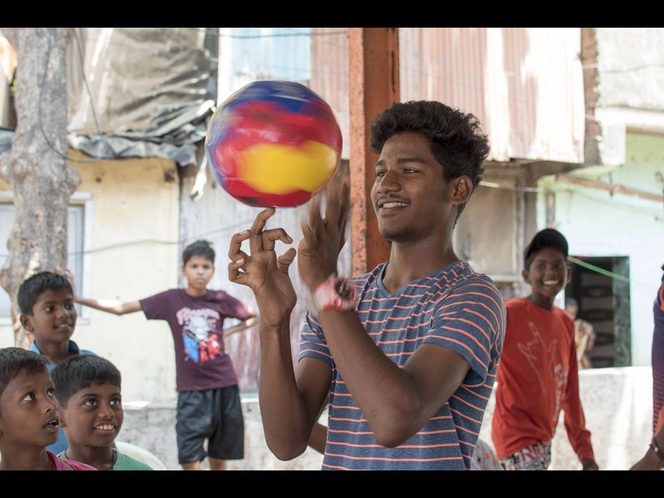 Surya (17) shows off some tricks with a football. He visits his friends near a temple in Maharashtra