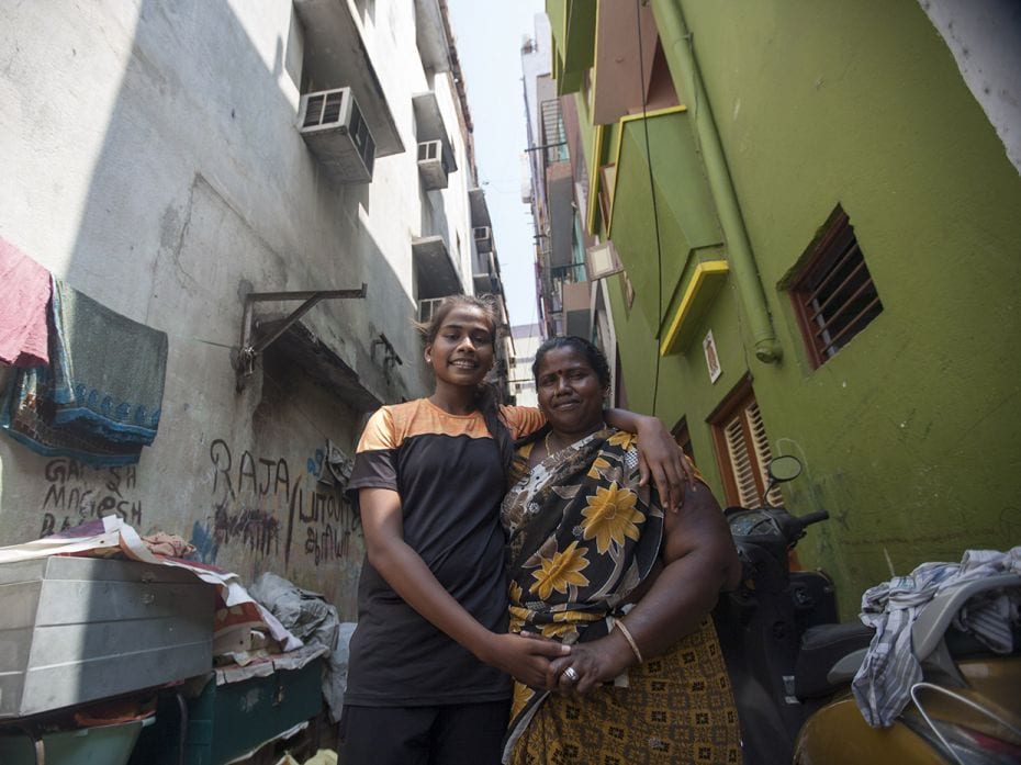 Monisha (14), poses with her mother, Kuttiammal, on the street that they live on. Her mother works a