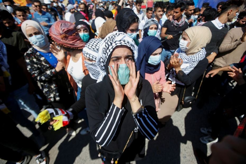 IRAQ: A student wears a protective face mask following the outbreak of the coronavirus, as she chant