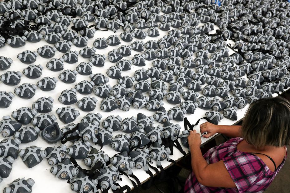 BRAZIL: An employee puts straps on protective face masks at Destra Brasil factory, which struggles w