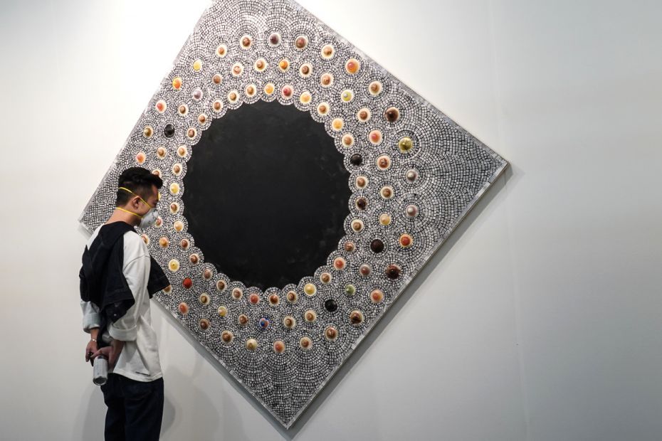 USA: A masked visitor stares at an artwork that resembles a void at the 26th edition of The Armory S