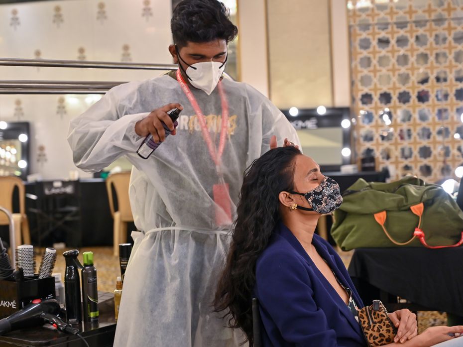 Hair stylists prepare a model backstage with safety precautions in place, at the shoot for Lakm&eacu
