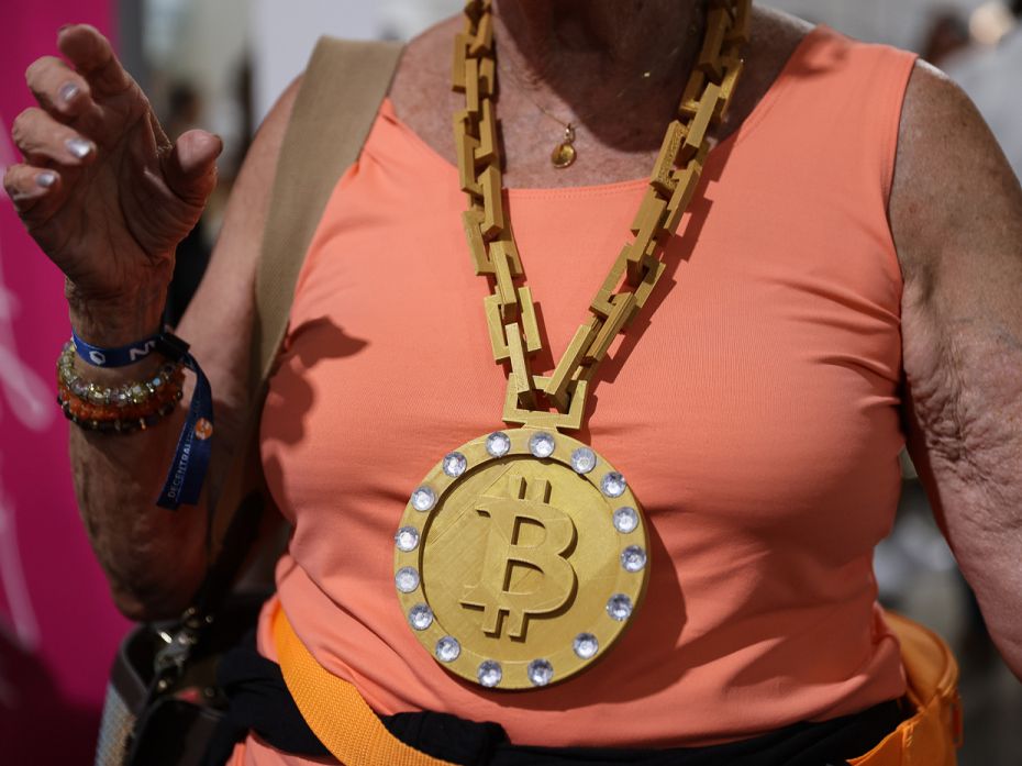 An elderly attendee wears a necklace to declare her faith in crypto at the Bitcoin 2021 Convention