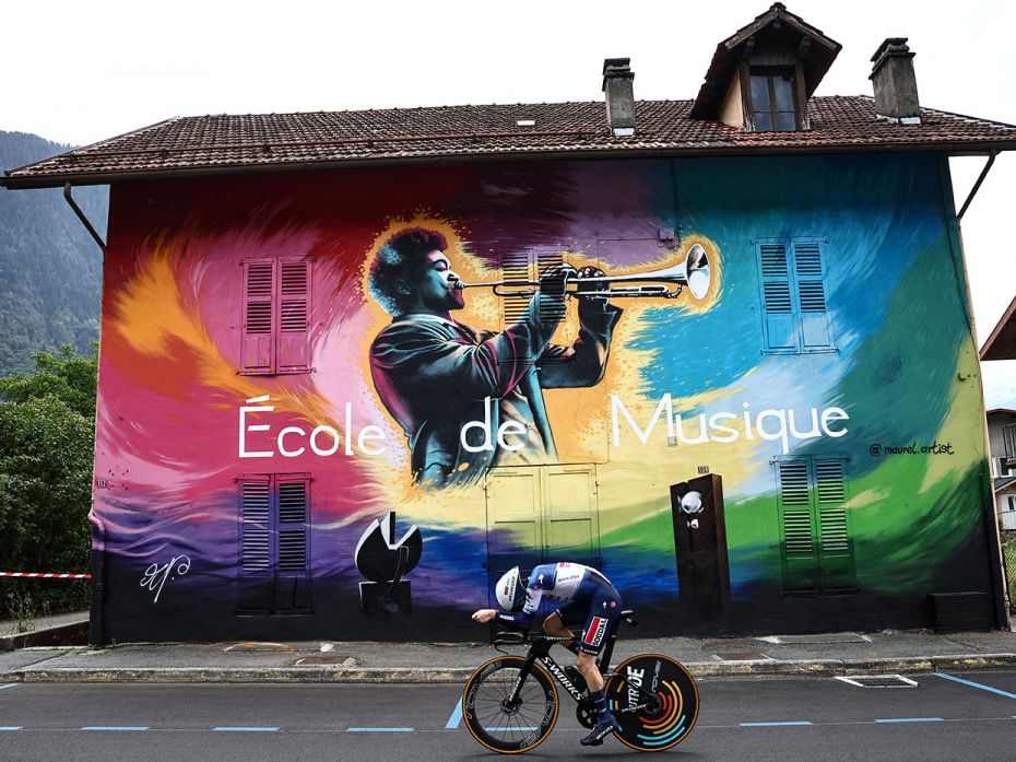 Soudal Quick-Step's rider Dries Devenyns cycles past a mural by artist Nicolas Maurel during the 16t