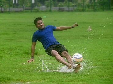 A young man plays football at the waterlogged Sector 33 ground on July 9, 2023, in Noida, India.