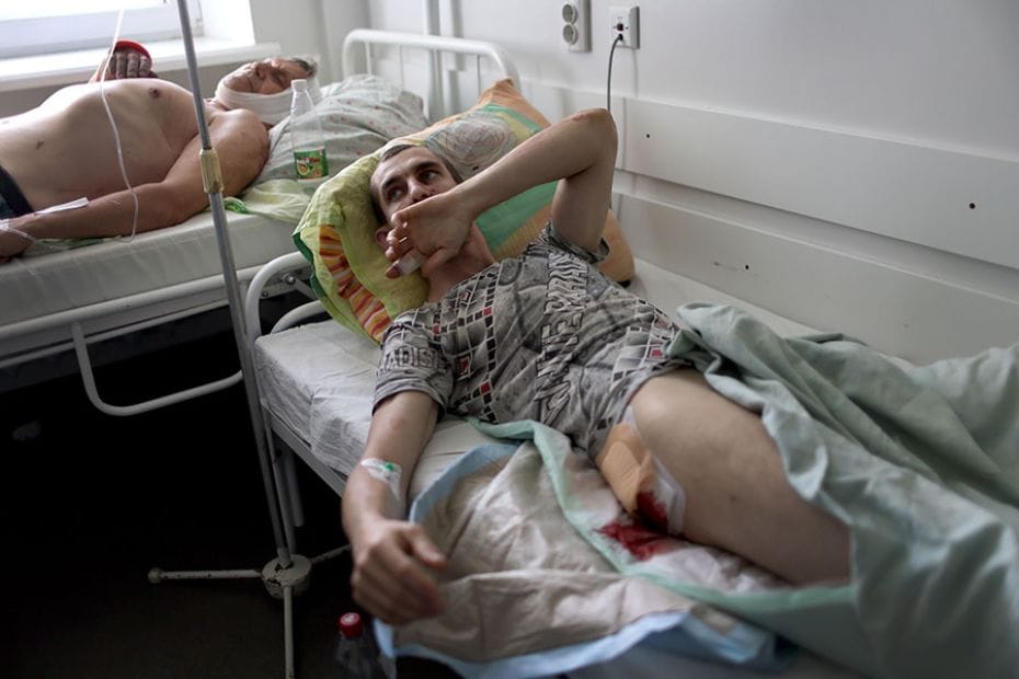 Men are treated in the hospital after they were wounded in cluster bomb attacks on June 30, 2022, in