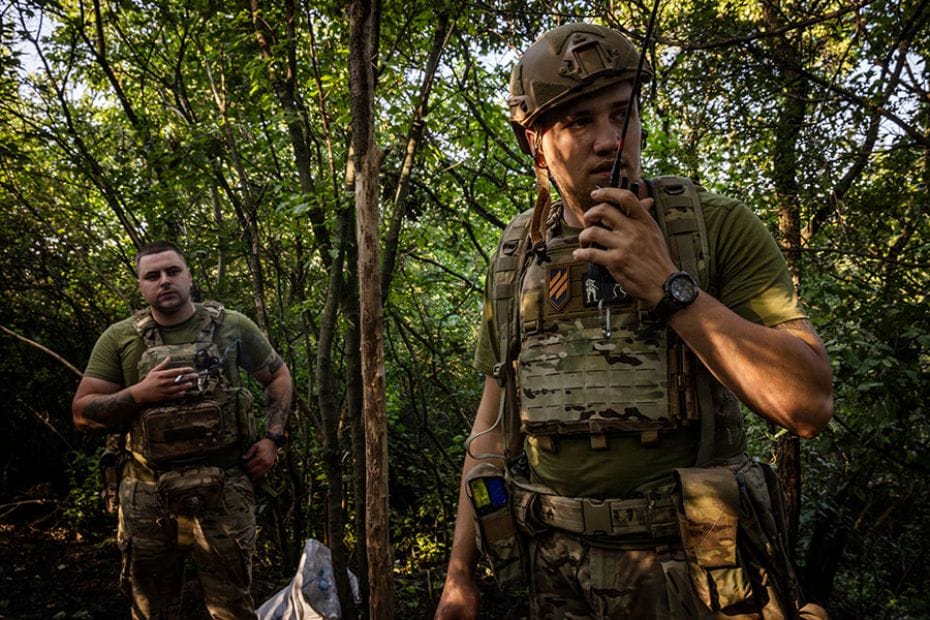 A soldier with the call sign Gerych (right) from the 3rd Assault Brigade talks on a radio at the bas