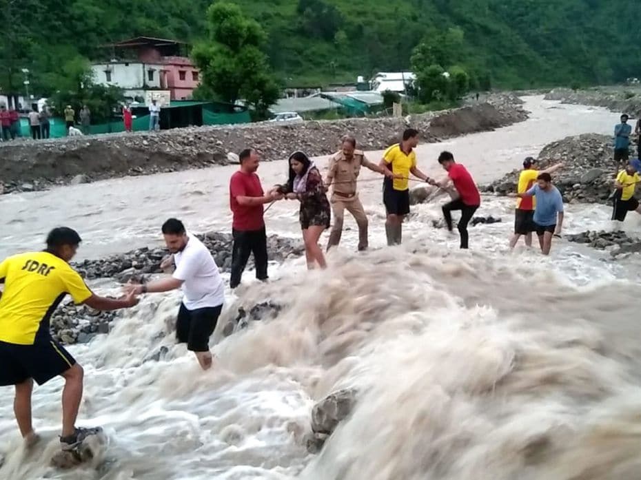 State Disaster Response Force personnel rescue stranded tourists after heavy monsoon rains washed aw