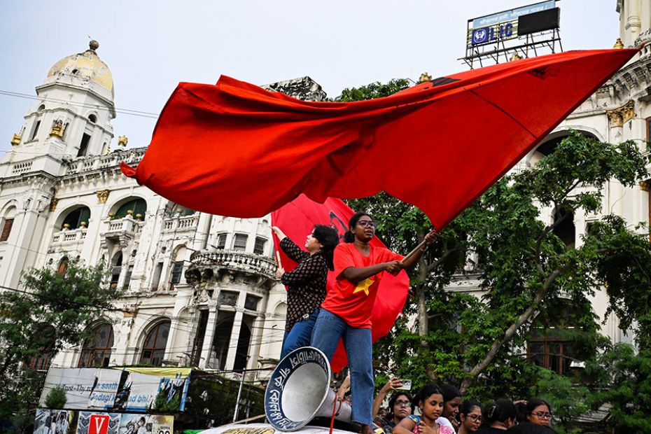 Activists shout slogans and wave flags during a protest rally to condemn the rape and murder of a tr