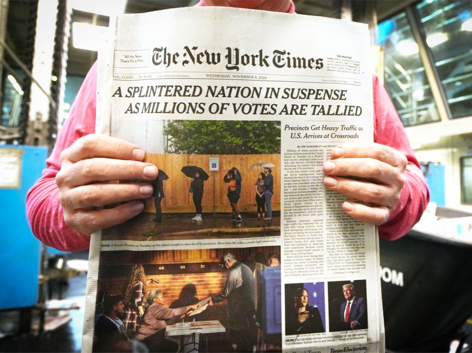 A production director of the New York Times holds the November 6 edition of the newspaper's front pa