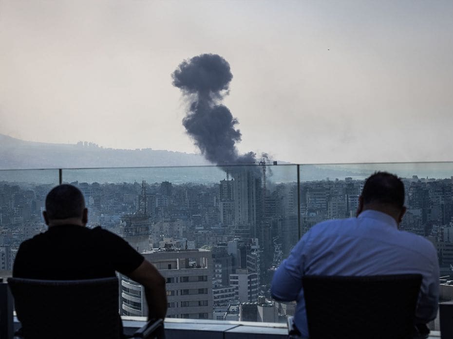 People watch smoke rise over Beirut's southern suburbs as a series of Israeli airstrikes rocks the c