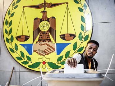 A man casts his vote before the National emblem of Somaliland, a breakaway region of Somalia, at a p